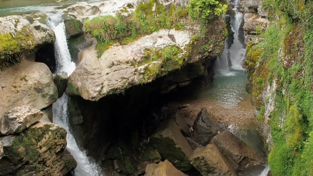 Waterfall in a humid tropical forest. Stormy stream of a mountain river. Beautiful waterfall in the forest. Pure water falls down from the mountains. A stormy stream of spike with a spray slow motion