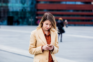 Fototapeta premium businesswoman typing message by phone on the city square