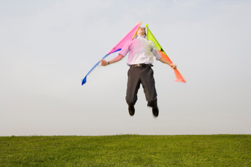A man leaping into the air with wings attatched to his arms