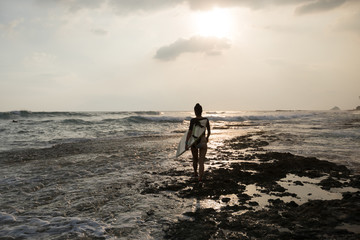 Woman surfer with surfboard going to surf