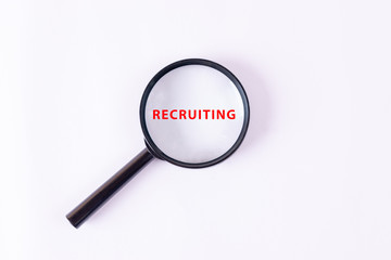 Recruiting concept. An enlarged fragment of expression in the lens of a magnifying glass with text 