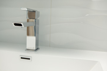 Chrome faucet in white bathroom