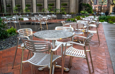 Empty dining tables and chairs in a street cafe after the rain