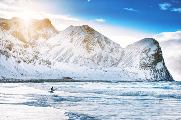Surfing on picturesque arctic beach Unstad on Lofoten islands in Norway, the iconic travel destination for surfers of all over the world. Location - Norwegian sea coastline, Scandinavia, Europe. © Feel good studio