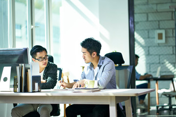two asian business people working together in office