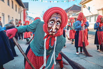 Pretty witch is holding a broom. Street Carnival in Southern Germany - Black Forest.