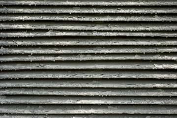 Old metal ventilating grill covered with peeling gray paint. For design, banner and layout.