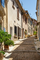 Fototapeta na wymiar Narrow cobblestone street opposite the Arles amphitheatre, France