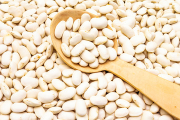 Dry lima beans stone background, with wooden spoon, top view, wallpaper, close up, macro.