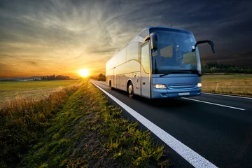 Foto op Plexiglas Bus traveling on the asphalt road in rural landscape at sunset © am