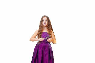 Naklejka premium Beautiful little girl with long hair in evening dress, portrait emotionally posing with a knife and fork, isolated