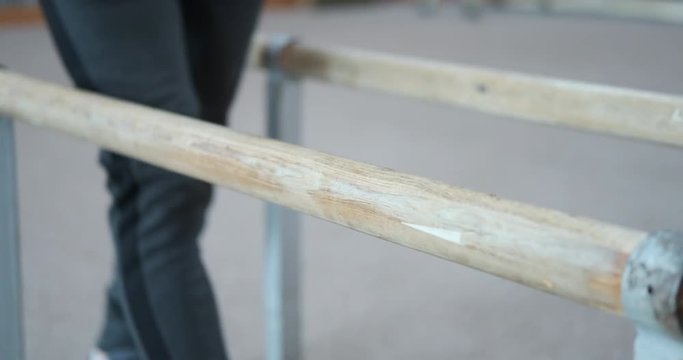Male gymnast performing handstand on parallel bars at gym