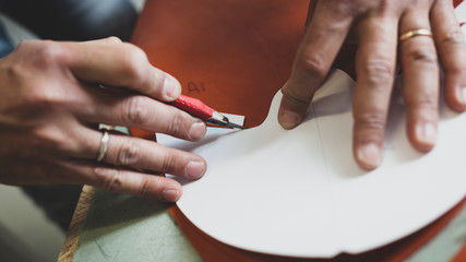 Shoe designer working with leather.