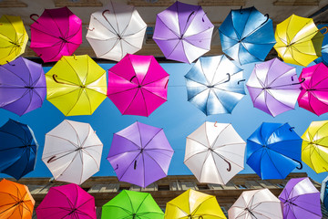 Street art consisting of multi coloured umbrella's in Arles, France