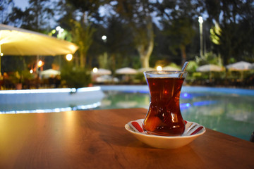 tea on the desktop next to the pool. Turkish tea. turkish te glasses