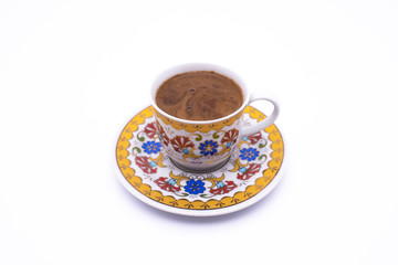 Turkish coffee in a white cup isolated on a motifed background (path included). Traditional Turkish Coffee