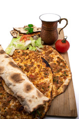 Turkish pizza, lahmacun, isolated on white background. lahmacun on a wooden table. Horizontal. one rolled with fresh garnish on the white surface.Cold buttermilk (ayran) near it.Close up taken,isolate