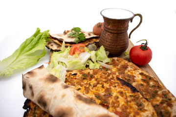 Turkish pizza, lahmacun, isolated on white background. lahmacun on a wooden table. Horizontal. one rolled with fresh garnish on the white surface.Cold buttermilk (ayran) near it.Close up taken,isolate