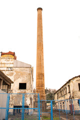 Fototapeta premium Industrial pipe isolated on white. old stone factory chimney. Isolated old aged weathered tall industrial factory chimney