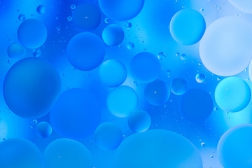 transparent glasses with water with oily drops on colorful background 