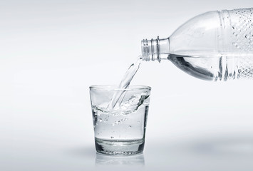 Water in bottle poured into glass. World Water Day