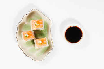 The concept of Japanese and Chinese cuisine. Sushi rolls laid out on a plate and soy sauce. On white background