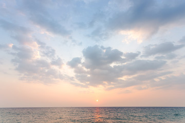 wide soft blue sky have some cloud with orange light color from sunset then spread to the sea