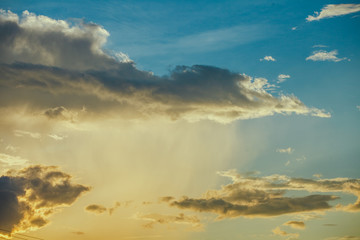 sunshine with pouring rain and dark clouds  on over blue sly