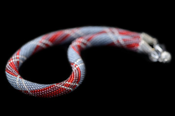 Classic style necklace with geometry print isolated on a black background close up