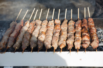 Roast meat on wooden sticks. Meat is fried on charcoal.