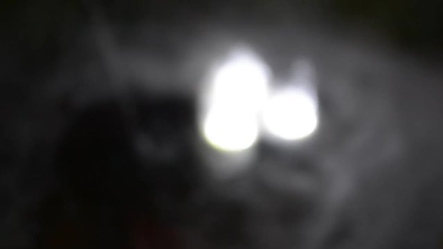 Closeup of three subtle and blurry pulsating lights with dripping water and mysterious mist abstract clip.
