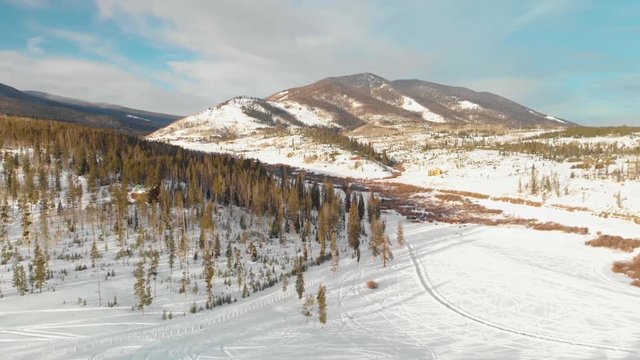 Drone flying in front of mountain in Fraser Colorado. Snow, trees and mountains in background.
