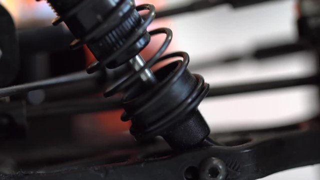 Black spring with a car damper during working macro shot.