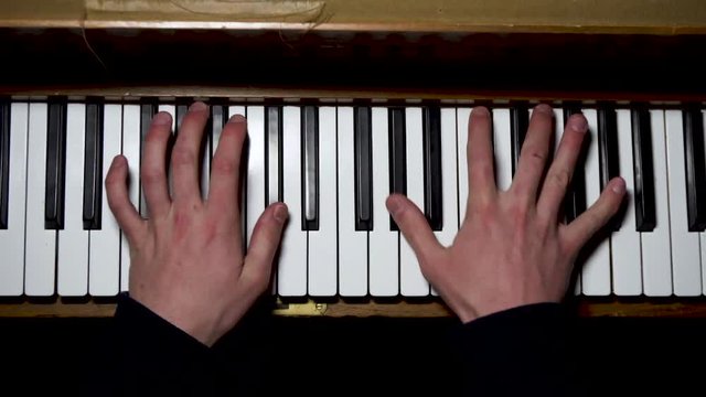 Birdseye view of hands playing a piano.