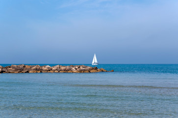 morning seascape with sailboat in the distance