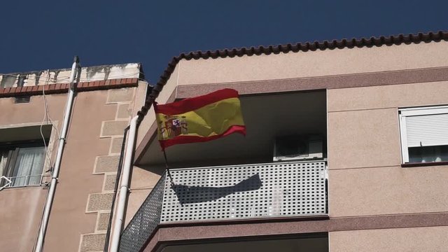 A close up of a Spanish flag blowing in the wind.