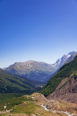 Fototapeta na wymiar Alpine river in the valley of mountains in the surroundings of Dombai. Caucasus Mountains summer, clear day from the forest.