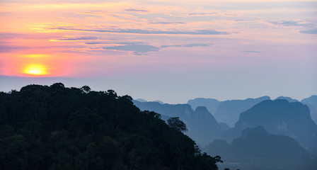 Naklejka premium Stunning sunset behind some beautiful limestone mountains. Picture taken from the Tiger Cave Temple (Wat Tham Sua) Krabi, Thailand.