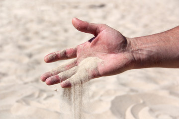 sand pours from the male palm close-up