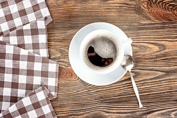 A cup of black hot coffee on a wooden table.