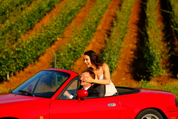 Bride And Groom Driving Away In  convertible car