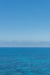Fototapeta premium Clear Blue Sky Over the Turquoise Waters of the Southern Mediterranean Sea on the Italian Coast