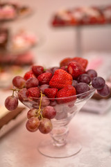 Fruits in glasses on white table