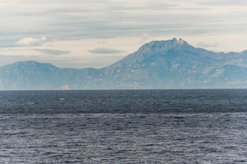 Fototapeta na wymiar Mediterranean Sea with Mountains in the Distance on the Southern Italian Mediterranean Coast on a Cloudy Morning