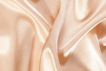 Silk background, texture of beige shiny fabric