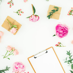 Obraz premium Floral frame of pink peonies, roses, hypericum and eucalyptus with clipboard and gifts on white background. Flat lay, top view