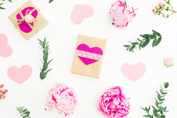 Pink peonies, roses, envelope and gifts on white background. Flat lay, top view