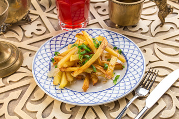 Delicious homemade fried potatoes with aromatic spices on oriental table