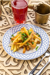 Delicious homemade fried potatoes with aromatic spices on oriental table