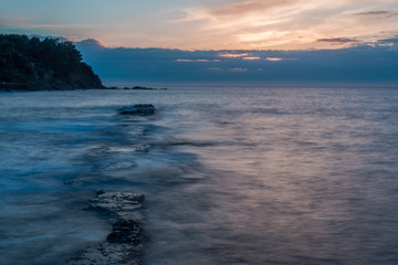 Obraz premium Long Exposure of a Sunset on the Southern Mediterranean Sea in Italy with Ancient Roman Wall